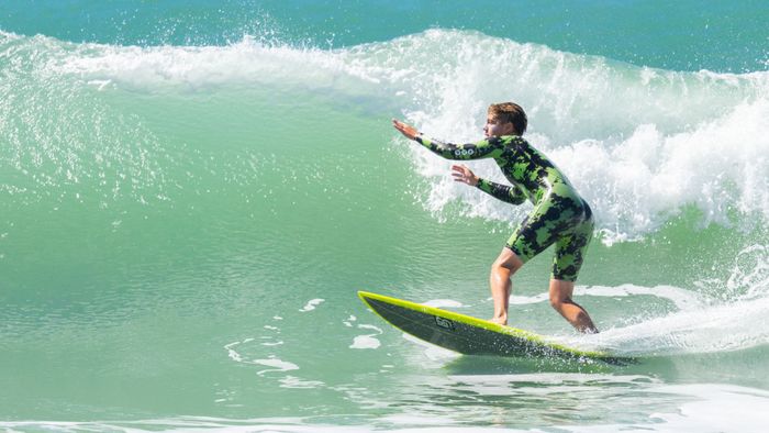 Surfer riding a wave on a sunny day, showcasing skill and adventure.