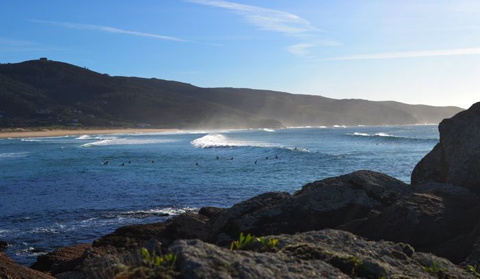 Captivating view of coastal waves meeting rocky shores under a clear sky.