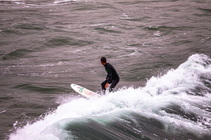 A surfer skillfully rides the waves off the coast of Bournemouth, England.
