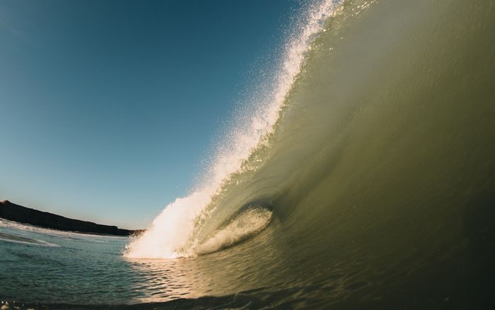 Dynamic capture of an ocean wave crashing in Mar del Plata, Argentina. Clear skies enhance the vibrant scene.