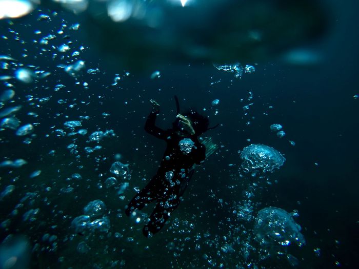 A scuba diver surrounded by bubbles deep underwater, showcasing the beauty of marine exploration.