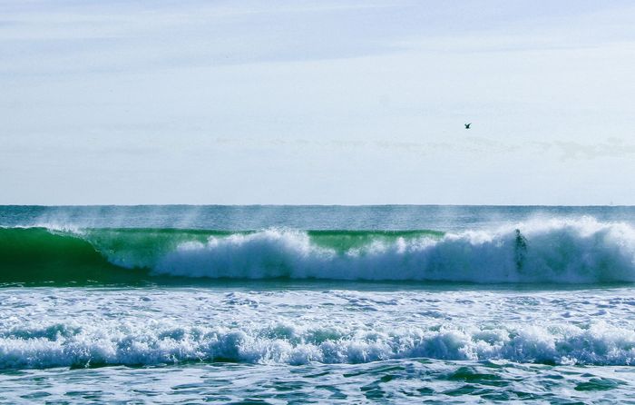 A vibrant scene of surfing at Asbury Park Beach, capturing ocean waves and serene skies.