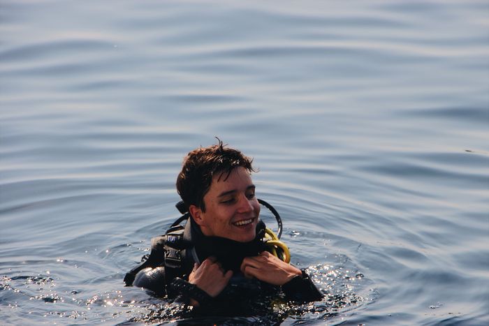 A joyful scuba diver enjoying a refreshing swim in the calm ocean water.