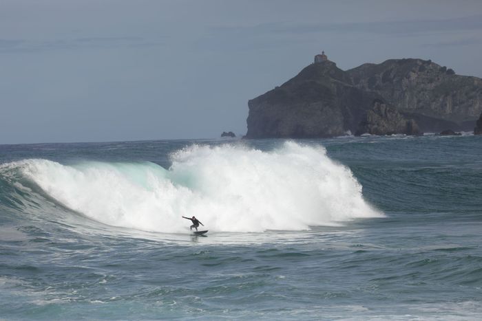 Experience the thrill of surfing near the iconic Gaztelugatxe island in the Basque Country, Spain.