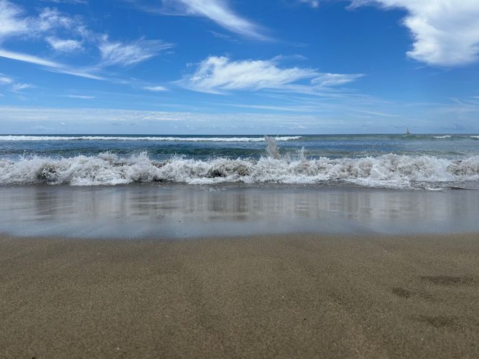 Idyllic sandy beach with gentle waves and vibrant blue sky. Perfect for relaxation and travel inspiration.