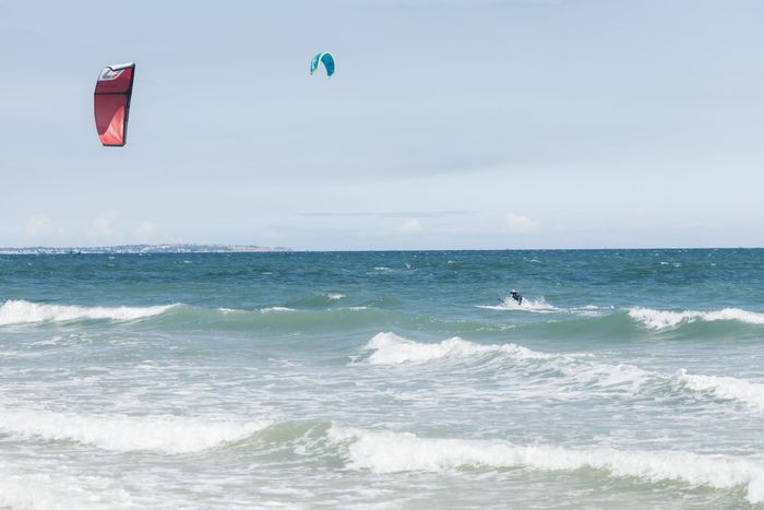 Dynamic kitesurfing scene with colorful kites and vibrant ocean waves, perfect for adventure seekers.