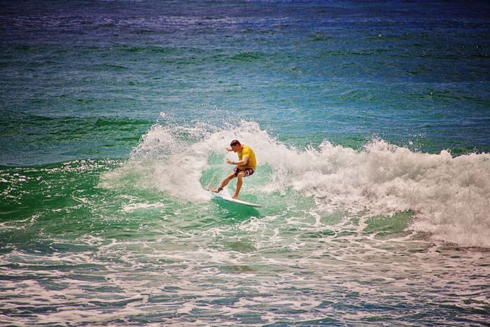 Surfer catching a wave at Bundall, QLD, showcasing skills and thrills in vibrant ocean waters.