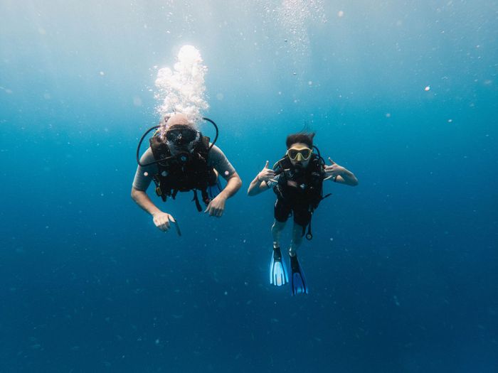 Two scuba divers exploring the vibrant underwater world off Zanzibar's coast in Tanzania.