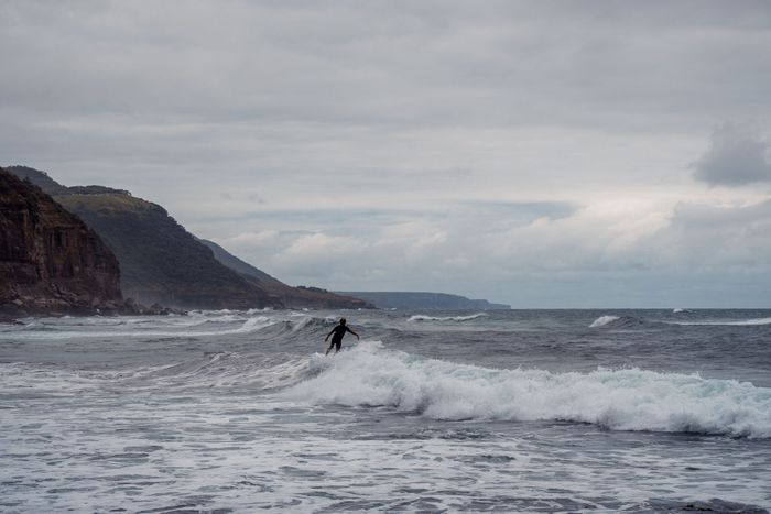 A lone surfer rides the waves at Stanwell Park Beach, Australia.
