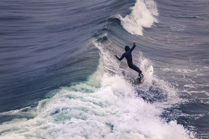 Dynamic shot of a surfer expertly riding waves at Pismo Beach, showcasing skill and thrill.