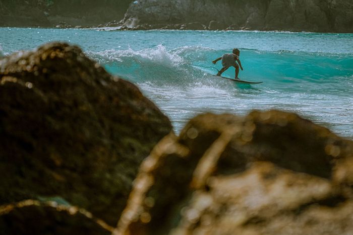 Experience thrilling surfing in East Java, Indonesia, with crystal clear turquoise waves.