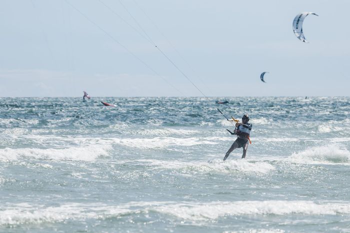 Man enjoying a thrilling kitesurfing experience on dynamic ocean waves.