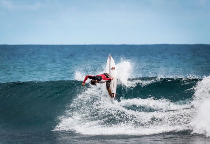 A surfer performs a thrilling maneuver on the vibrant waves of Brazil, showcasing skill and adrenaline.