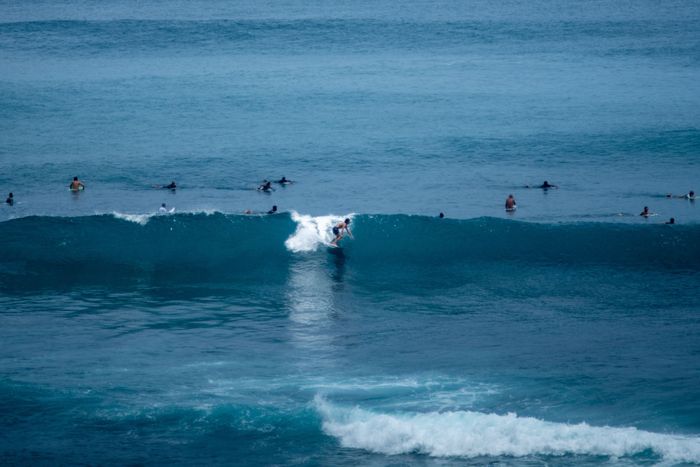 Surfers enjoying waves in Bali, Indonesia's vibrant ocean waters.