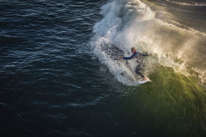 A surfer skillfully rides a wave at Pismo Beach, capturing the essence of exhilarating water sports.