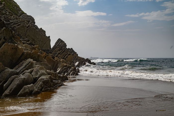 Explore the stunning rocky coastline of País Vasco with dramatic cliffs and crashing waves.