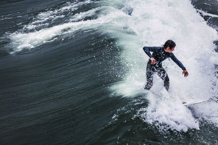 Dynamic shot of a surfer riding waves at Pismo Beach, California.