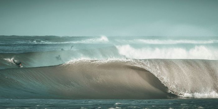 Dynamic ocean scene with surfers riding powerful waves in Mar del Plata, Argentina.