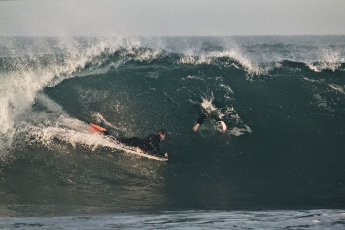 A surfer skillfully rides a massive wave, showcasing adventure and thrill in the ocean.