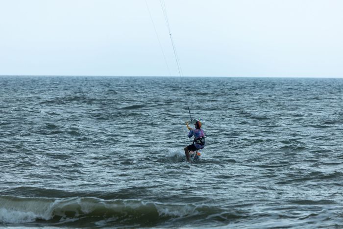 Kitesurfer enjoying a thrilling ride on open ocean waves. Ideal for summer fun and travel themes.