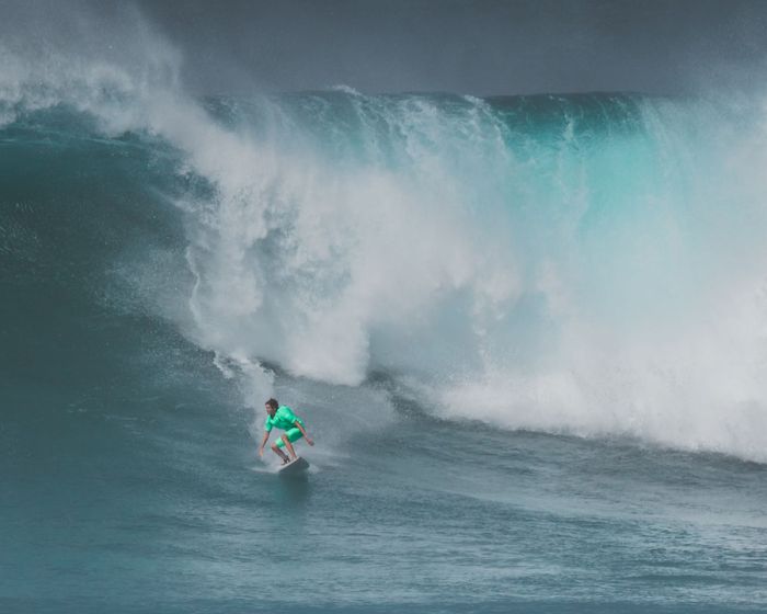 Exciting action shot of a surfer riding a big wave at Waimea Bay, Hawaii.