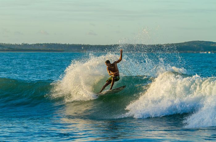 Surfer riding a wave in Baía Formosa, Brazil, showcasing skill and excitement.
