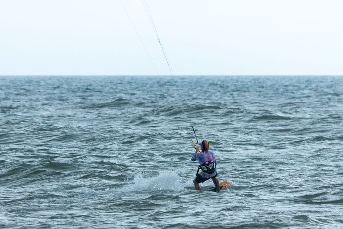 Kitesurfer gliding across the ocean, capturing the thrill of adventure and water sports.