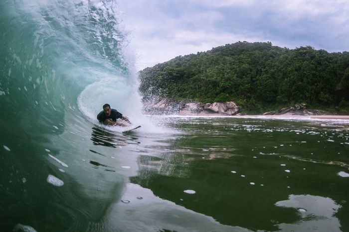Surfer rides an impressive wave at Ubatuba, Brazil, showcasing the thrill of ocean sports.