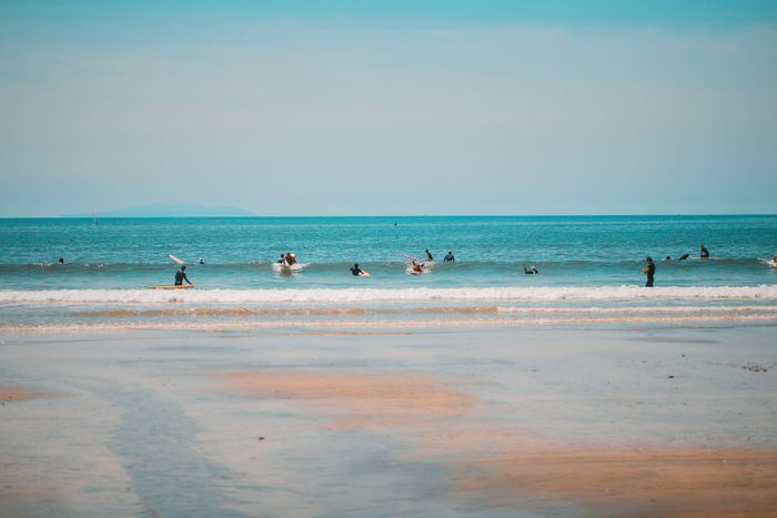 Surf enthusiasts enjoy the waves at Kamakura Beach, perfect for a summer adventure.