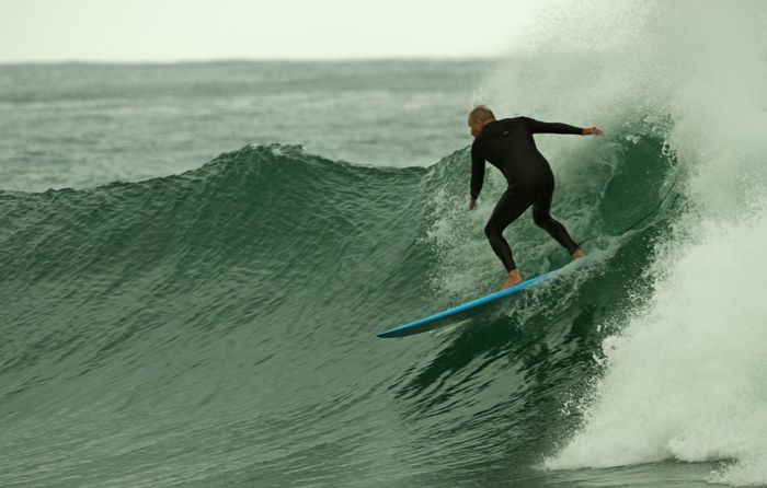 A surfer skillfully rides a big wave at Dolphin Coast, KZN, South Africa.