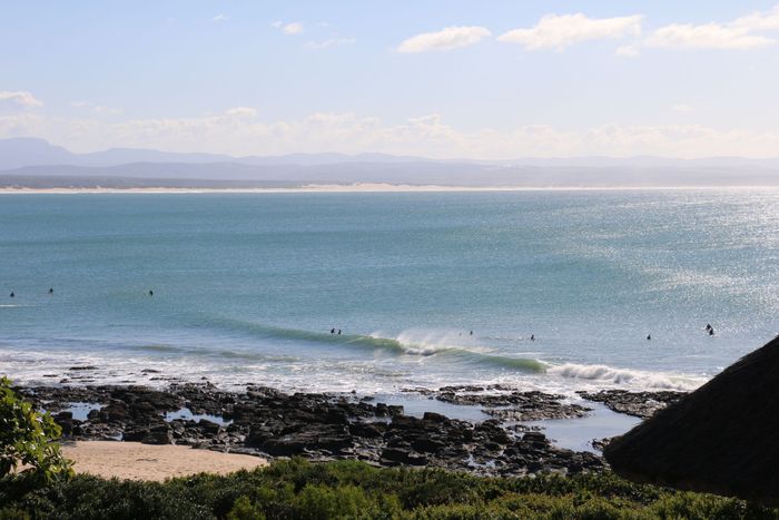 Beautiful view of the coastline at Jeffrey's Bay, South Africa, capturing surfers and blue skies.