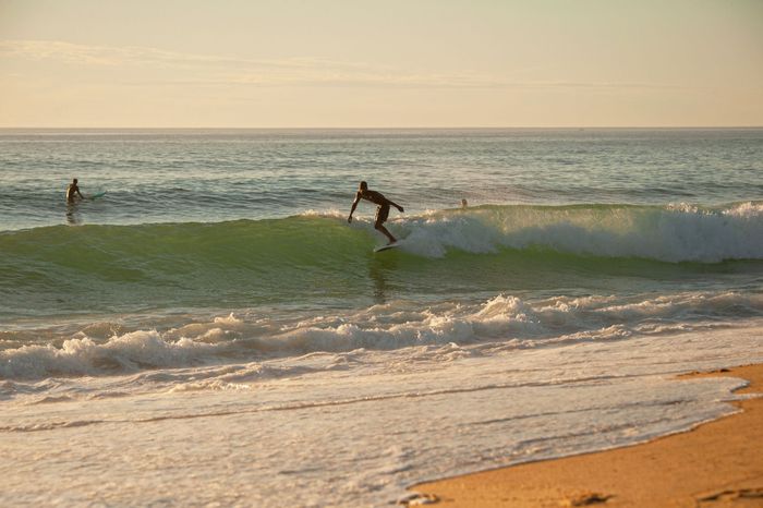 Surfers enjoying the waves at Seignosse beach during a sunny day, capturing the essence of outdoor adventure.