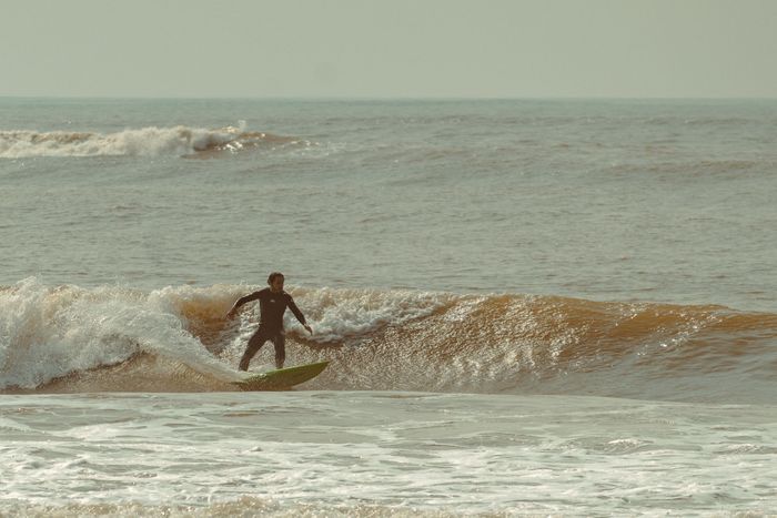 A surfer rides dynamic waves showcasing skill and balance in a thrilling ocean scene.