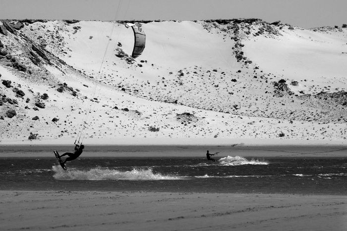 Experience the thrill of kitesurfing against the dramatic backdrop of Oued Ed-Dahab's desert dunes.